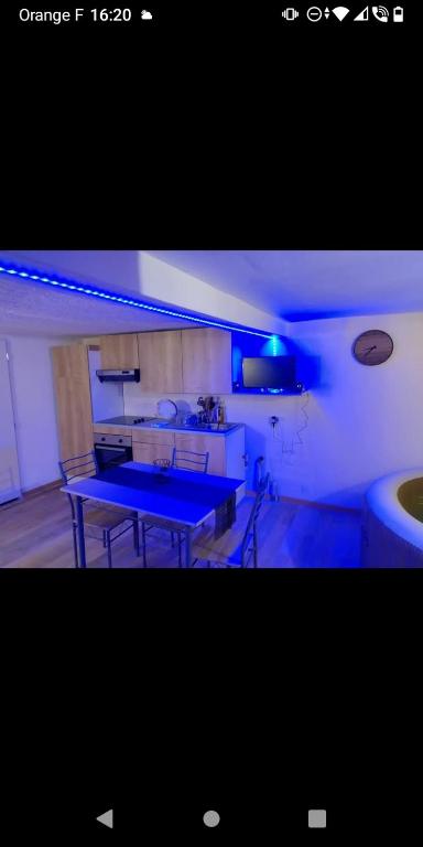 a kitchen with a blue table in a room at Bas de villa à 100 M de la plage in Solaro