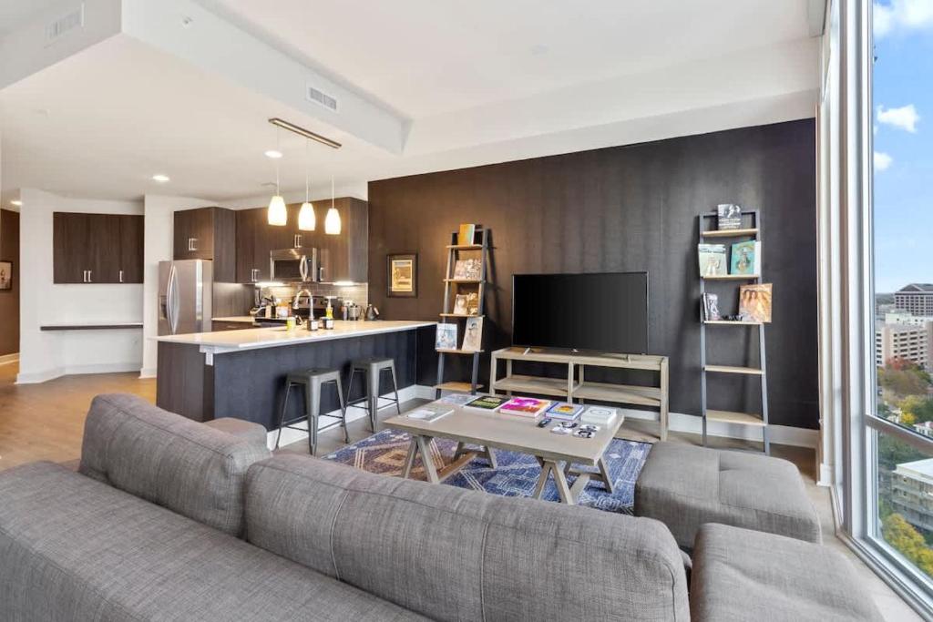 a living room with a couch and a kitchen at The Stevie Ray Vaughan Flat ATX in Austin