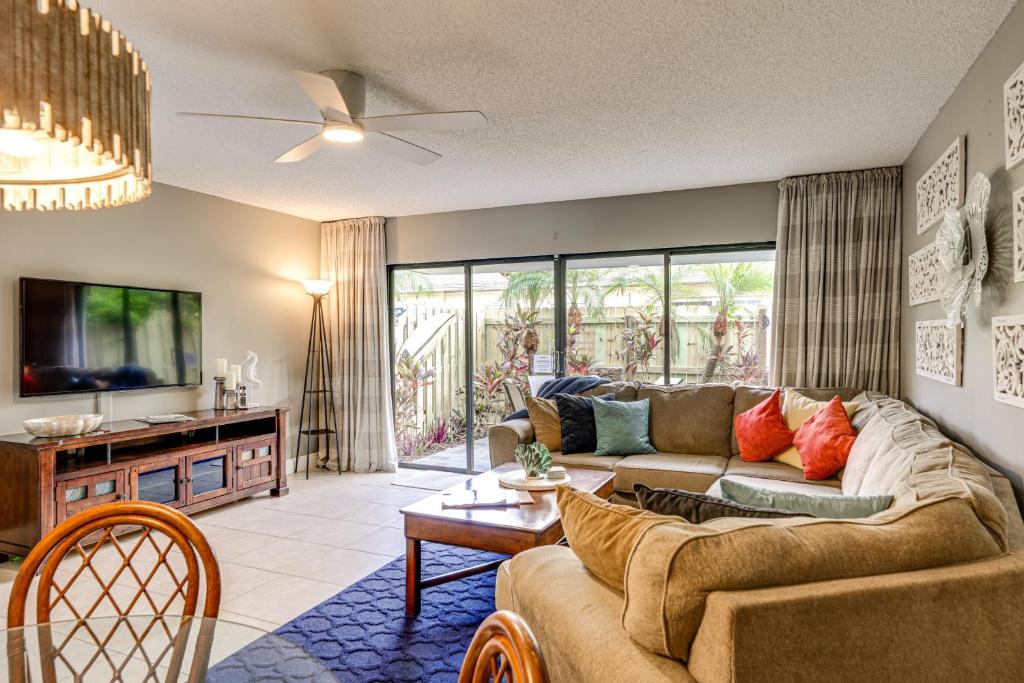 a living room with a couch and a tv at Steps to Shore Condo with Patio in West Palm Beach! in West Palm Beach
