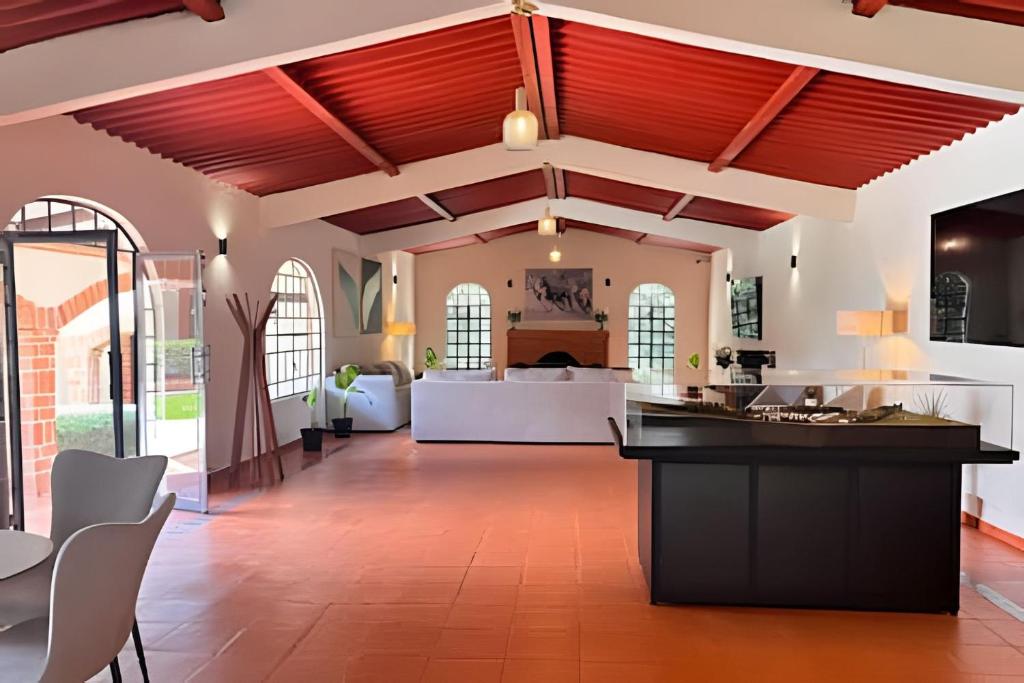 an open kitchen and living room with red ceilings at Refugio familiar en el bosque in Villa Victoria