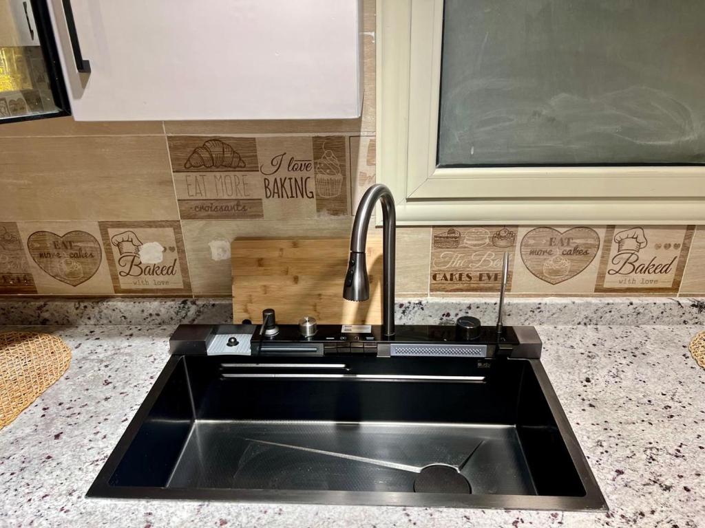 a sink in a kitchen with a counter top at Elegant apartment in New cairo