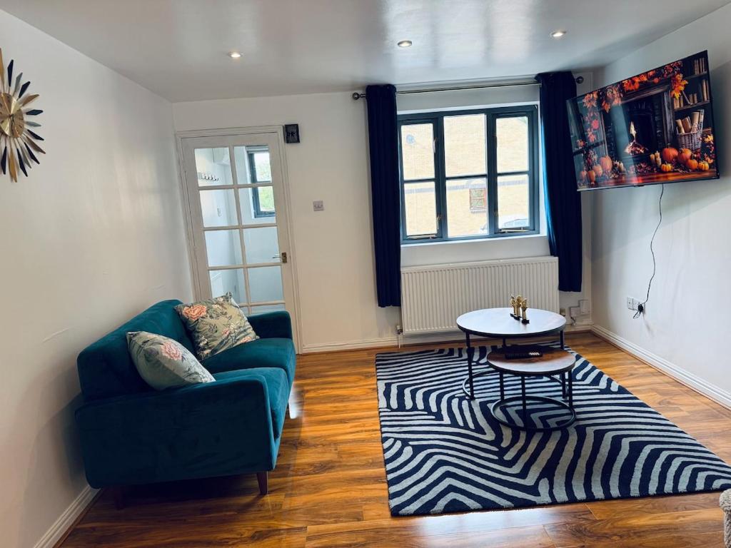 ein Wohnzimmer mit einem blauen Sofa und einem Zebra-Teppich in der Unterkunft Cozy Home In Headington, Oxford in Oxford