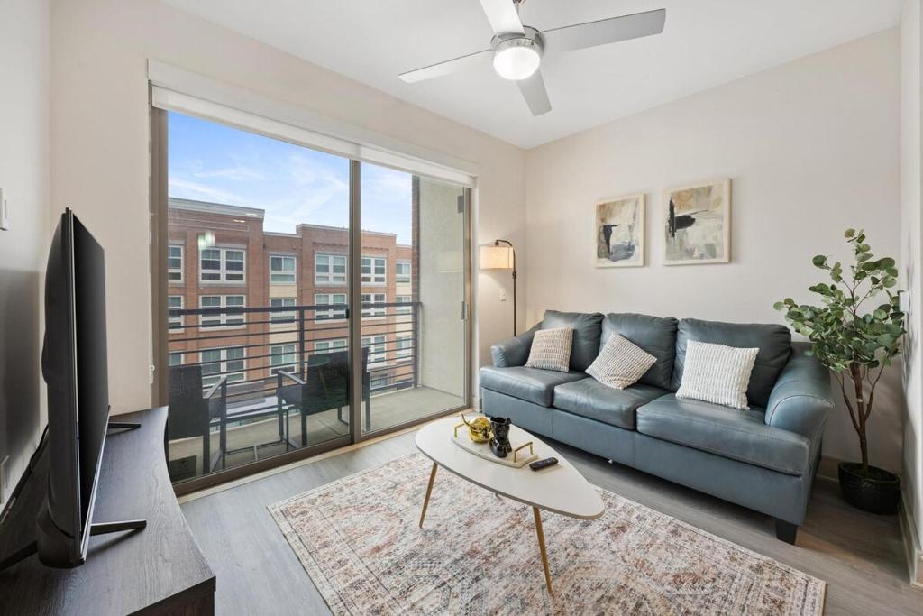 a living room with a couch and a large window at Chill & Tone 1BR Frisco King & Sofa, Gym & Pool in Frisco