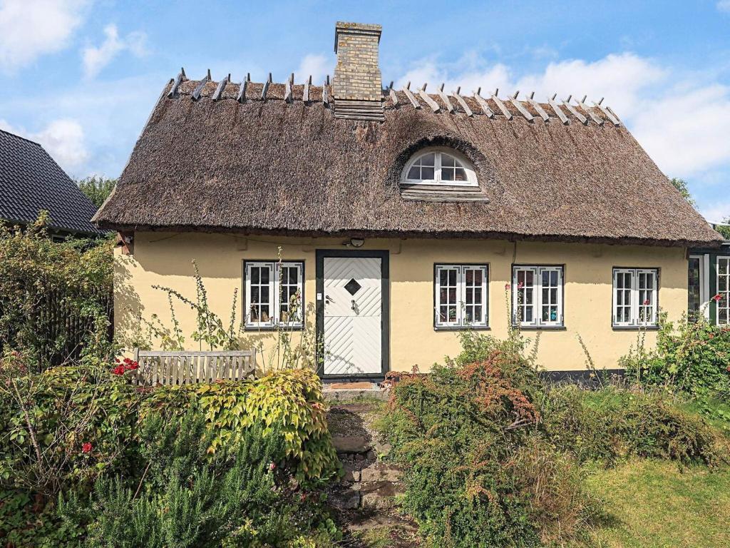 a small yellow house with a thatched roof at 4 star holiday home in Humlebæk in Humlebæk