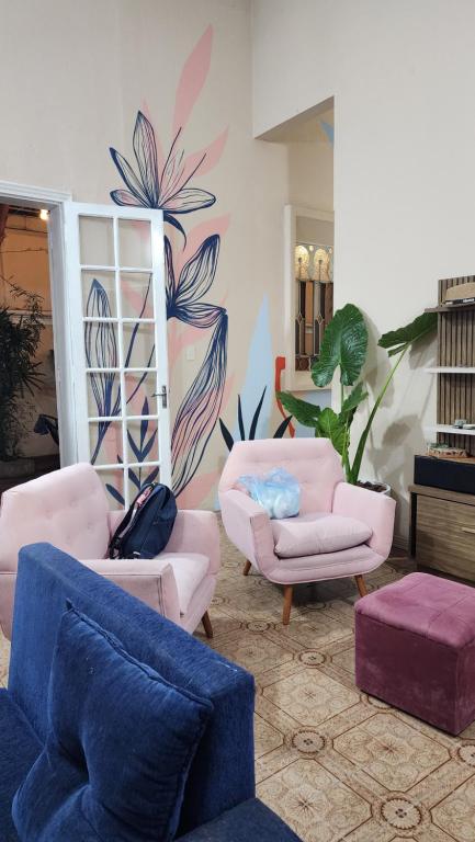 a living room with couches and chairs and a mural at Mandioca Hostel in Asuncion