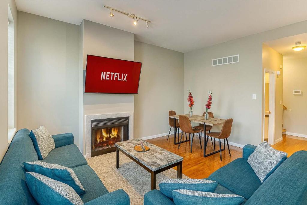 a living room with a blue couch and a fireplace at Spacious 4BR Soulard Duplex with Patio & Parking in Soulard