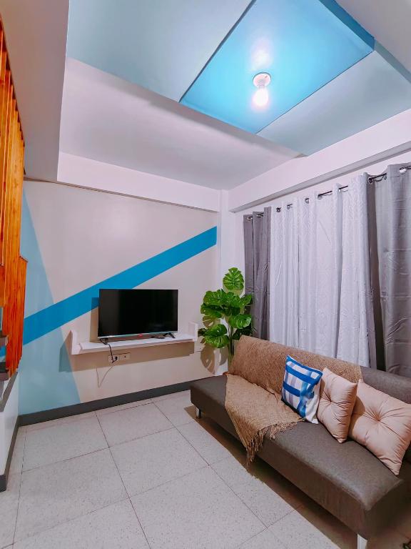 a living room with a couch and a tv at Gomez St 2BR Apartment in Downtown- Host Homes in Tacloban