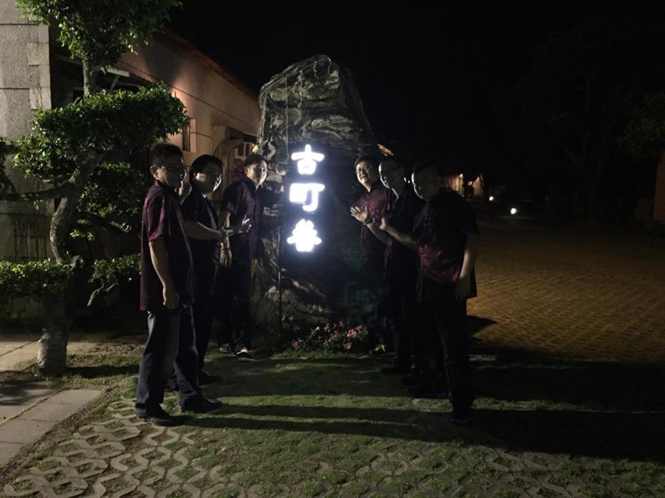 a group of people standing around a rock at night at Gu-Ting-Ben B&amp;B in Minxiong
