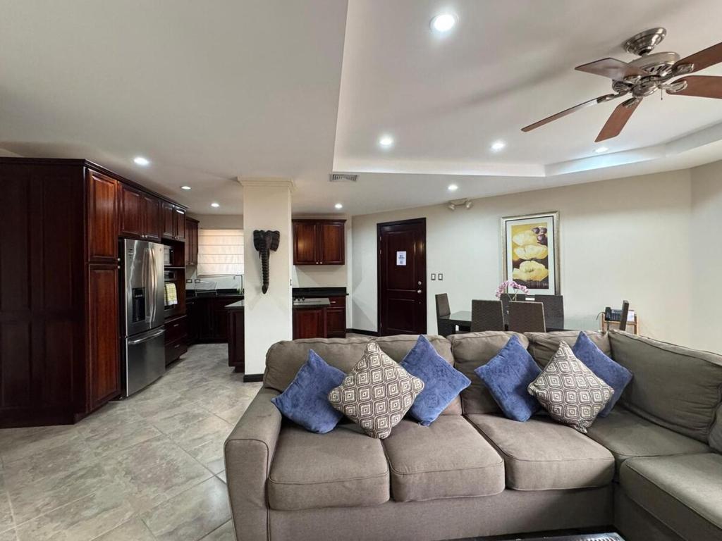 a living room with a brown couch with blue pillows at Monaco Condominiums, Jacó, Costa Rica - Luxury 3 Bedrooms in Jacó