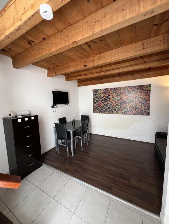 a living room with a table and chairs and wooden ceilings at Bonito Mini Departamento 9 in Puebla