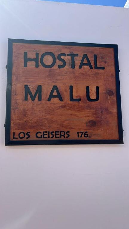 a sign for a hospital malinois on a wall at Hostal Malú in San Pedro de Atacama