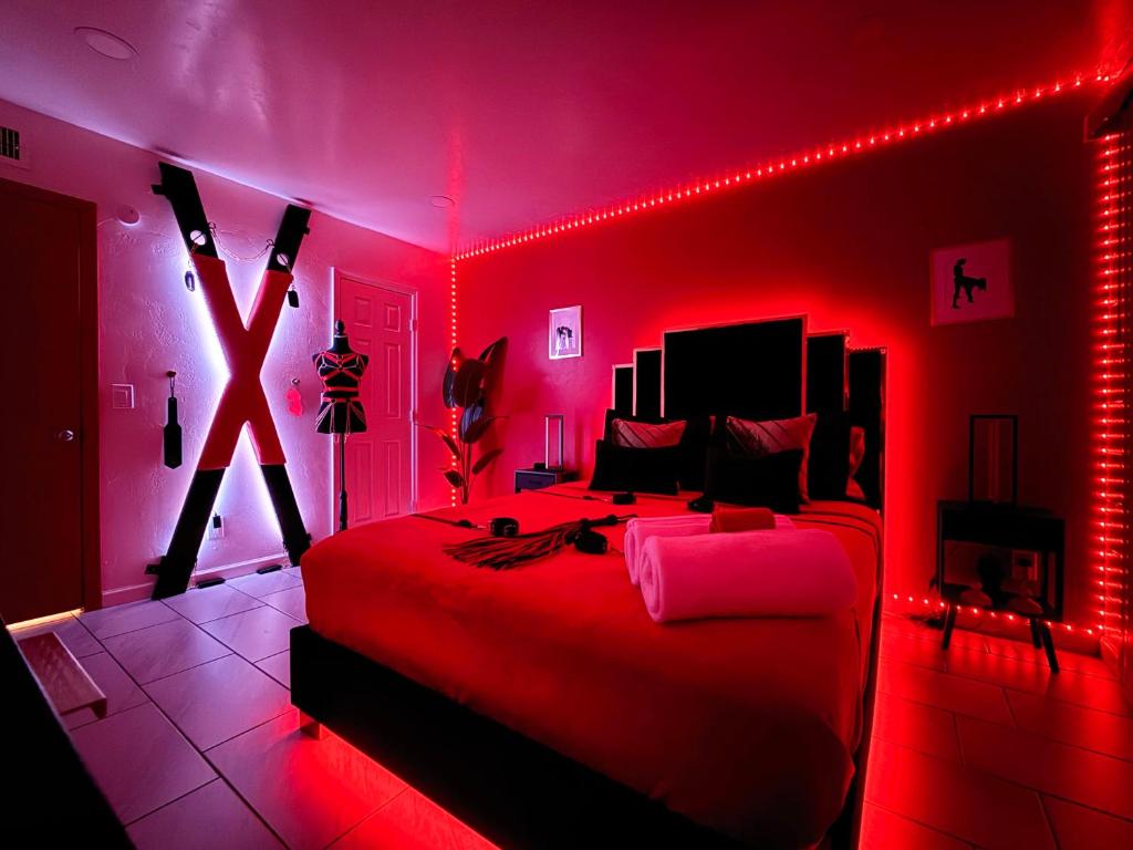 a bedroom with a bed with red lights in it at Luxury Lovers Escape Hot Tub & Fantasy Suite in Tucson