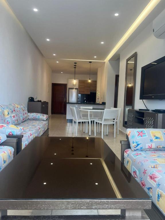 a living room with couches and a table and a kitchen at المضيق in Marina Smir