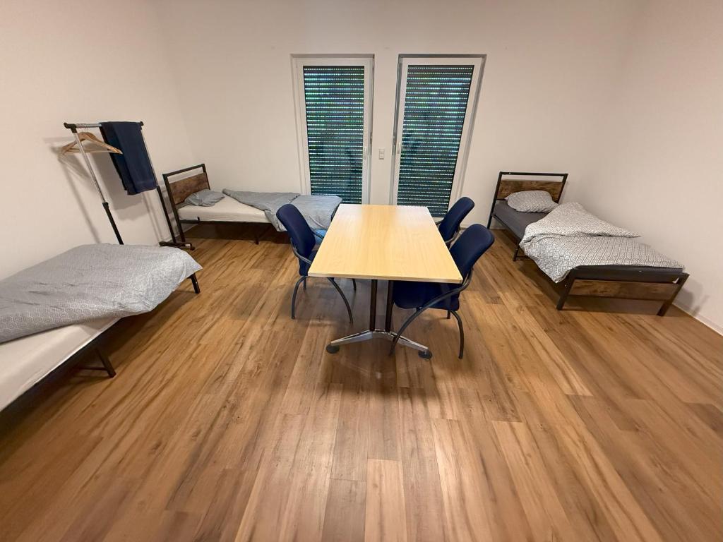 ein Zimmer mit drei Betten und einem Tisch und Stühlen in der Unterkunft Ferienzimmer No4 Ehingen in Ehingen