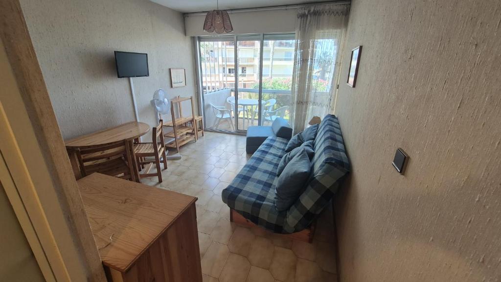 ein Wohnzimmer mit Sofa und Tisch in der Unterkunft Studio au pied de l'eau in Canet-en-Roussillon