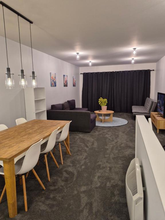 una sala de estar con una mesa y un sofá en Family friendly 2 bed apartment with carpark, en Wellington