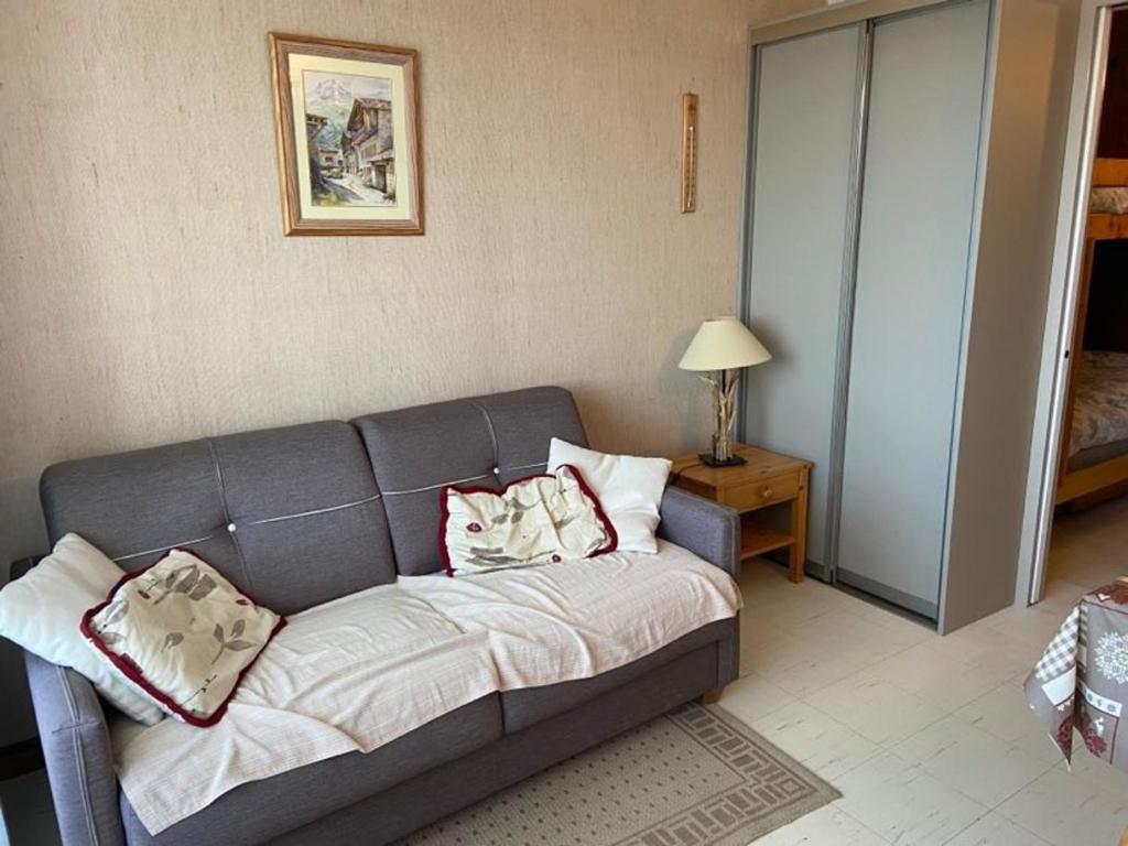 un soggiorno con divano grigio e cuscini sopra di Studio central Praz de Lys - 4 pers, balcon, proche pistes - FR-1-815-33 a Taninges