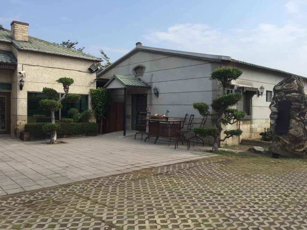 a house with a patio with a table and chairs at Gu-Ting-Ben B&amp;B in Minxiong