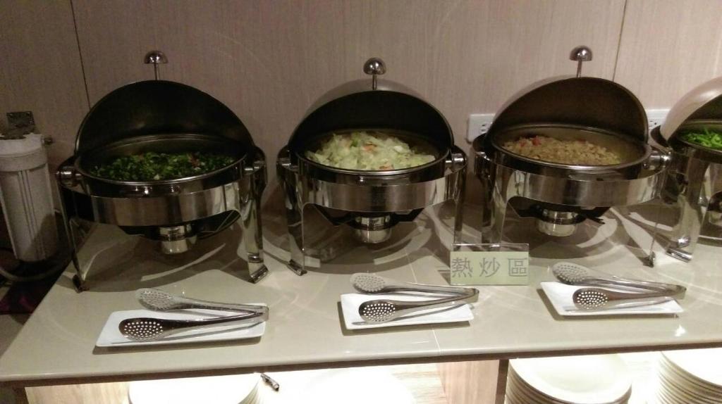 a buffet with three pots of food on a counter at Gu-Ting-Ben B&amp;B in Minxiong