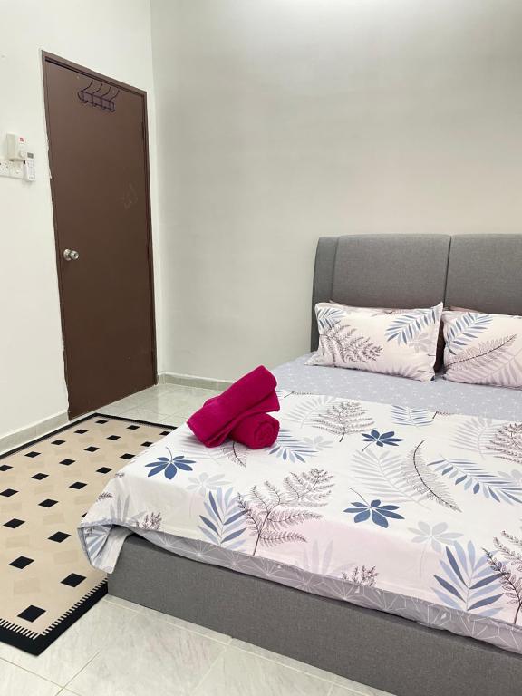 a bedroom with a bed with a red hat on it at InAw Homestay Kok Lanas in Kampong Pangkal Petai