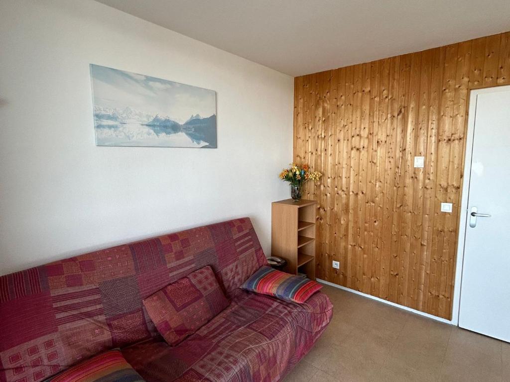 ein Wohnzimmer mit einer roten Couch in einem Zimmer in der Unterkunft Appartement Sud avec Terrasse et Garage à Super Besse - FR-1-814-96 in Besse-et-Saint-Anastaise