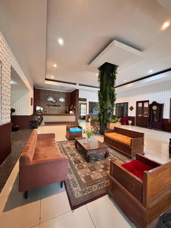 a large living room with couches and tables at Candra Dewi Yogyakarta in Yogyakarta