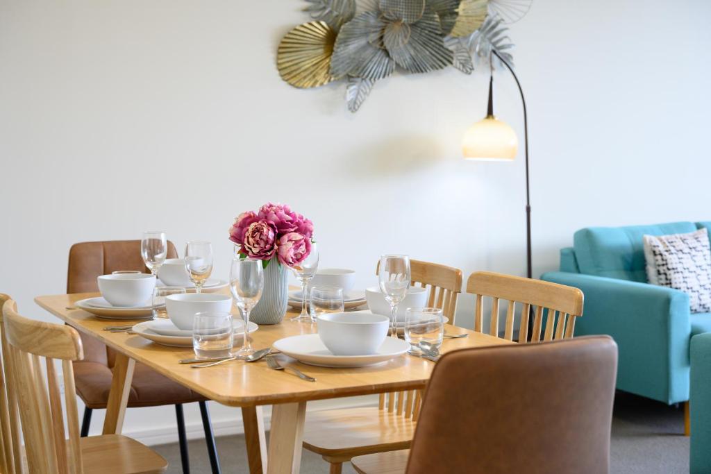 a wooden table with chairs and a dining room at Modern Comfort Hurstville 2BR Wifi Train Business in Sydney