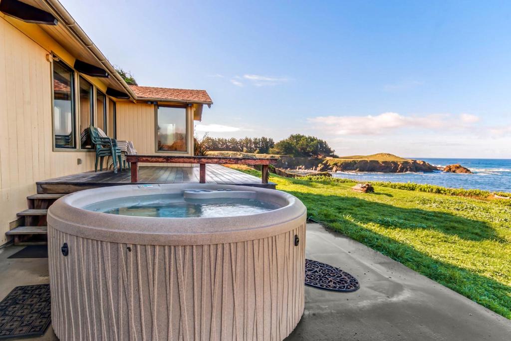 a hot tub on the patio of a house at Tideaway Private Hot Tub and Expansive Ocean View in Fort Bragg