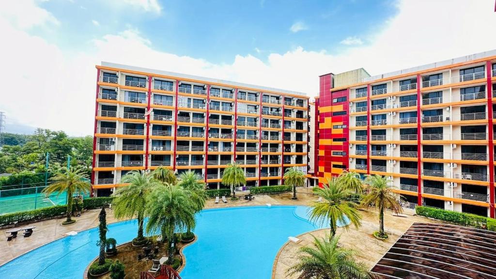 een hotel met een zwembad voor twee gebouwen bij Cozy condo maikhao Phuket in Ban Mai Salae