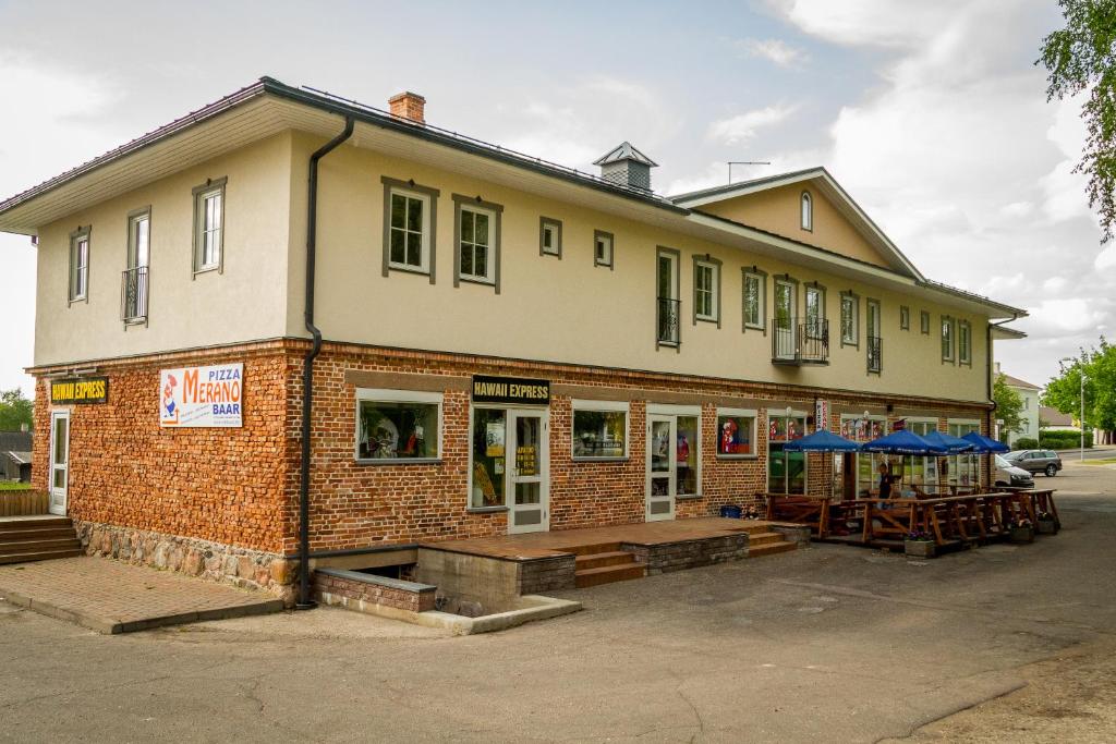 a brick building with tables in front of it at Otepää Apartments in Otepää