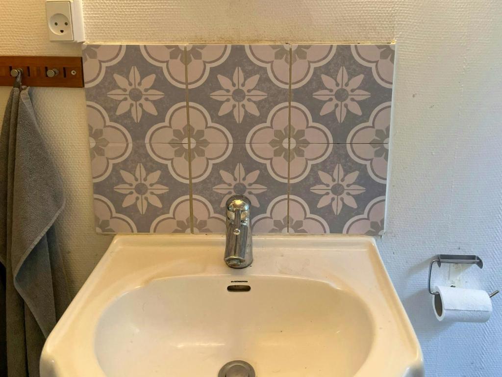 a sink in a bathroom with a flower wallpaper at Family-Friendly Holiday Home Near Skærby Beach in Nykøbing Sjælland