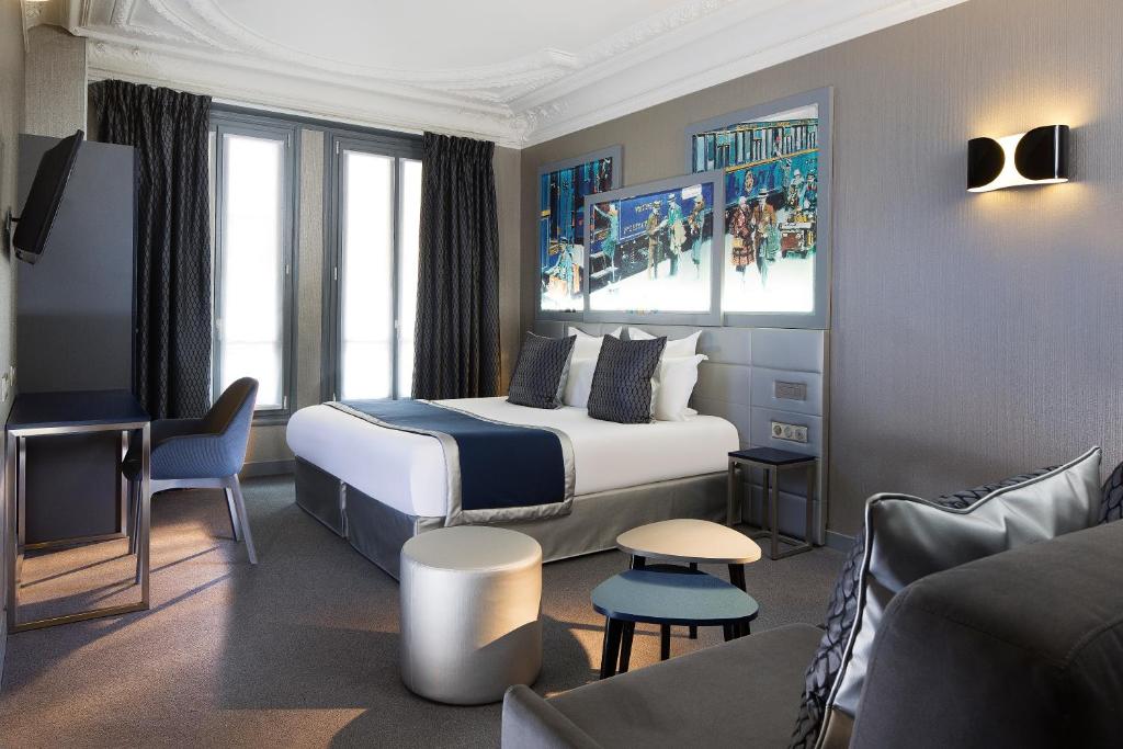um quarto de hotel com uma cama e um sofá em Palym em Paris