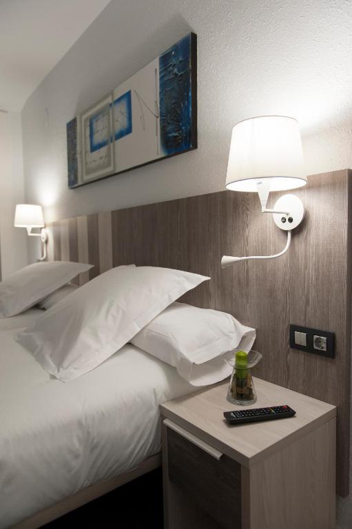 A bed or beds in a room at Hotel La Palma de Llanes