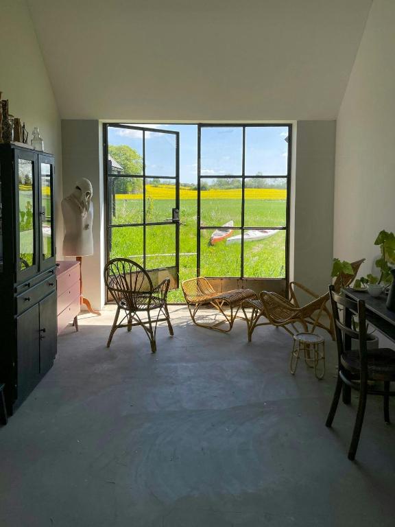 a room with a large window with chairs and a table at Renovated Scanian Farmhouse With Two Studios in Skåne-Tranås