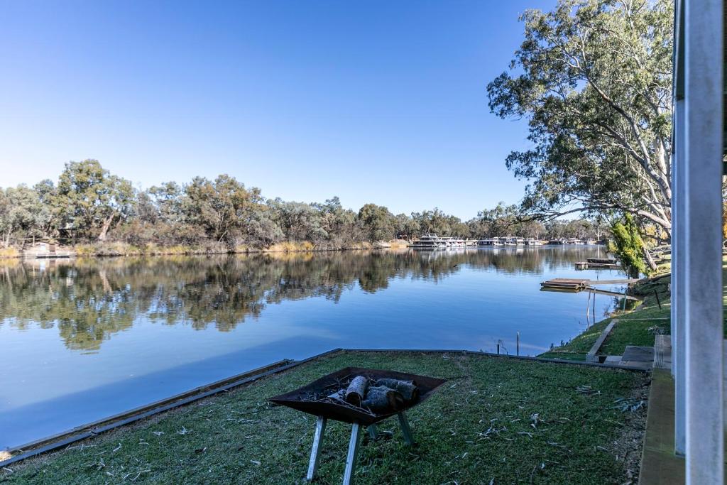 a fire pit on the grass next to a lake at 42 Old Murbko Road in Morgan