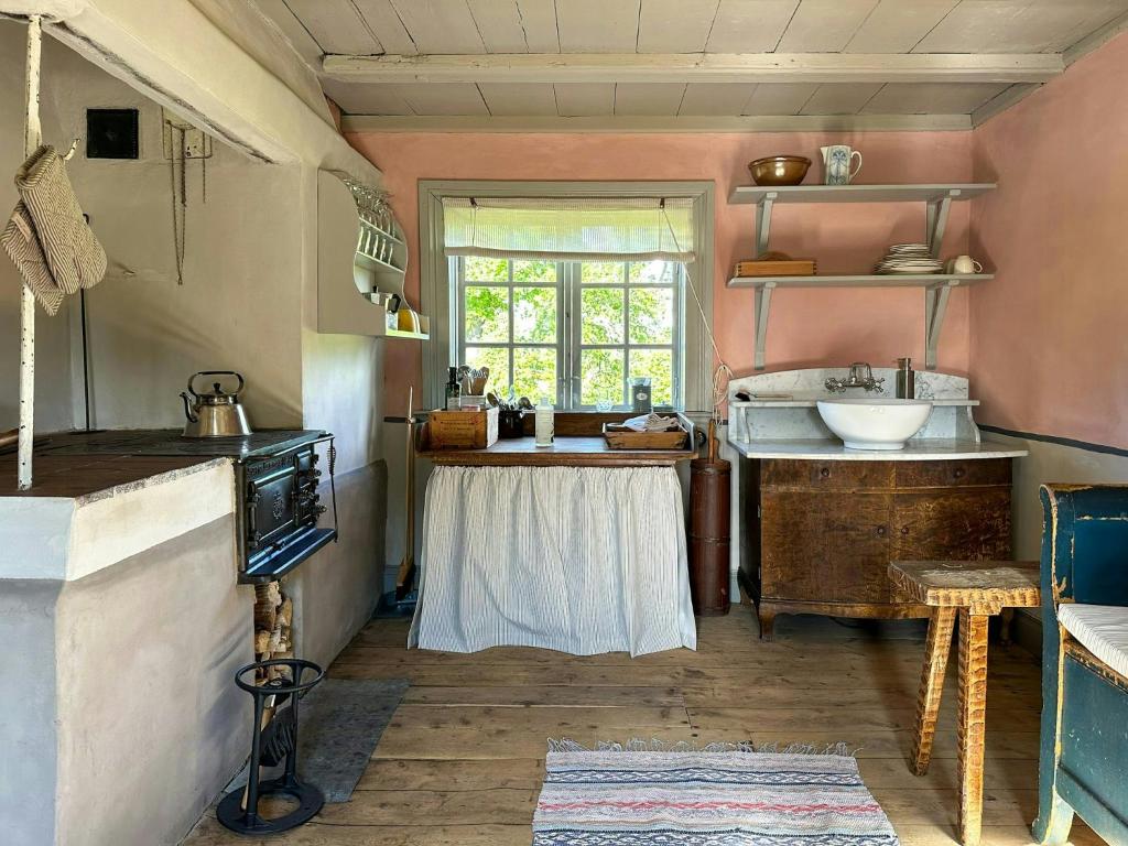 une cuisine avec un évier et une table dans une pièce dans l'établissement Historic Cottages At The 18Th Century Vicarage, à Varmlands Nysater