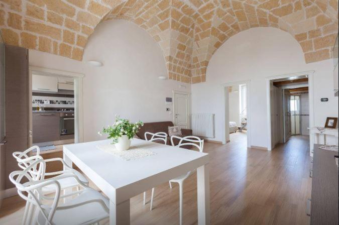 uma cozinha e sala de estar com uma mesa branca e cadeiras em Casa Vittorio Veneto em Carovigno