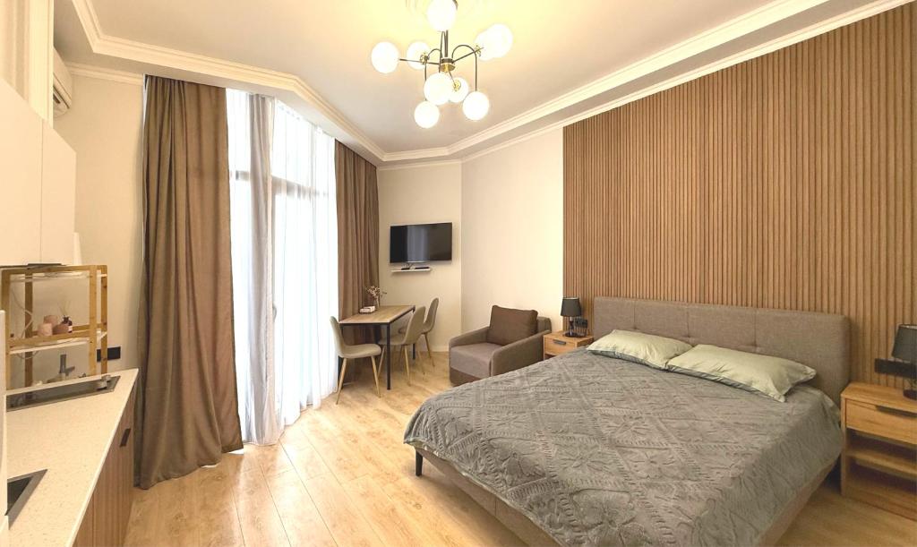 a bedroom with a bed and a chair and a table at SofiCoast in Gonio