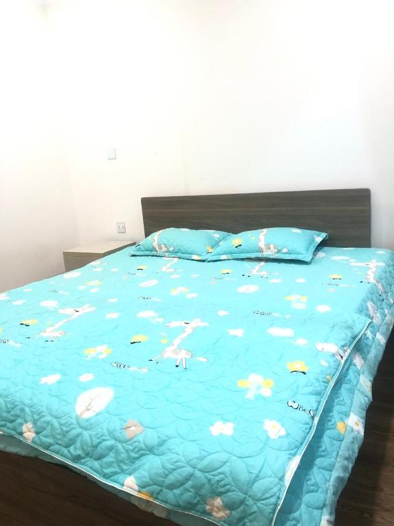 a bed with a blue comforter with animals on it at Lucky 12 in Bắc Ninh