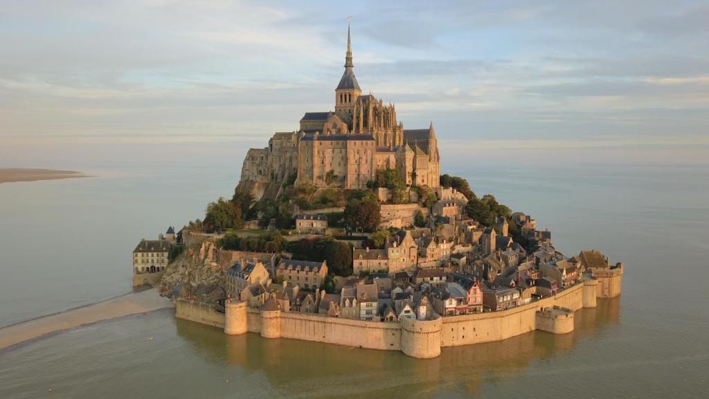 an island in the water with a castle on it at Mont saint michel normandie in Sainte-Cécile