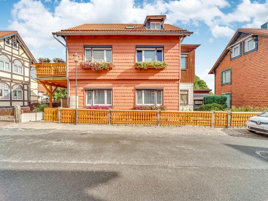 a orange house with a fence in front of it at Ferienwohnung im Herzen Ilsenburgs in Ilsenburg