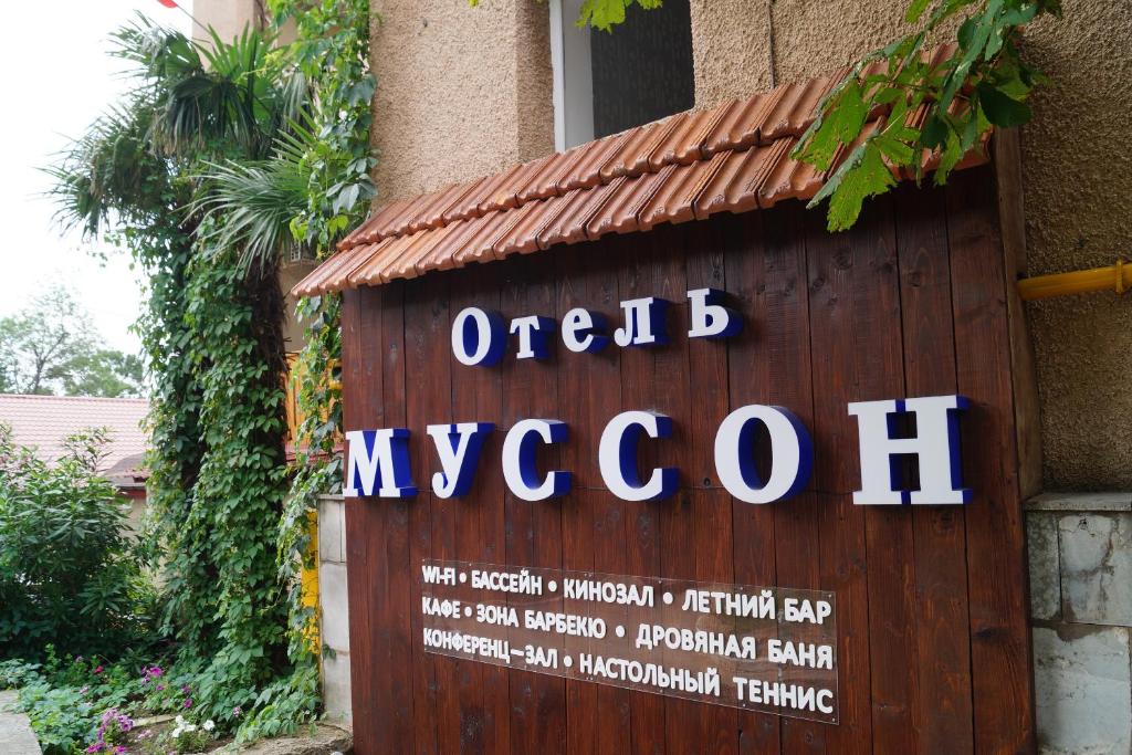 a sign for a hotel in front of a building at Musson Hotel in Yalta