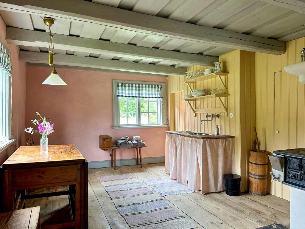 a kitchen with a table in the middle of a room at Historic Vicarage With Wood-Burning Stove in Eskilstuna