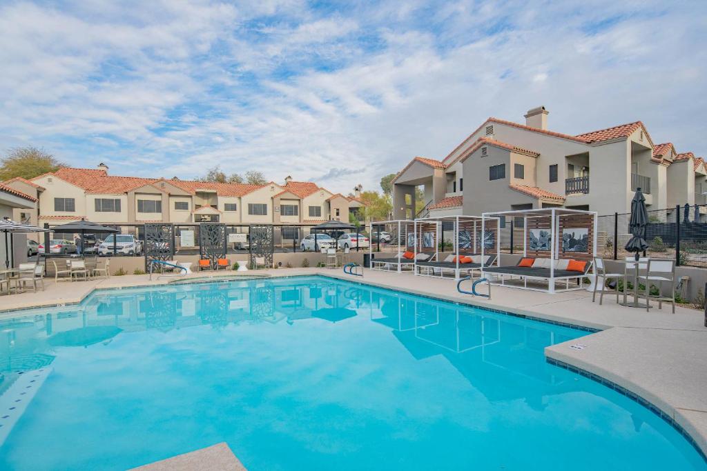 ein großer Pool mit Gebäuden im Hintergrund in der Unterkunft Family-Friendly Stay , Tennis & Basketball Courts, King Beds & Parking- H2167 in Scottsdale