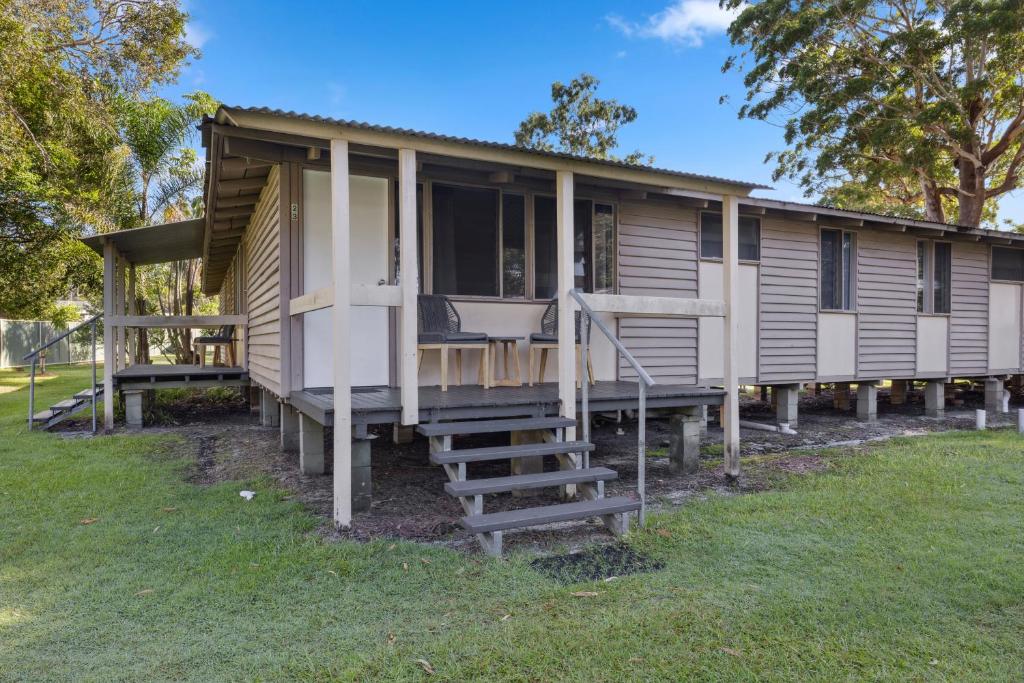 a manufactured home with a porch and stairs to it at Valla Beach Holiday Park in Valla Beach