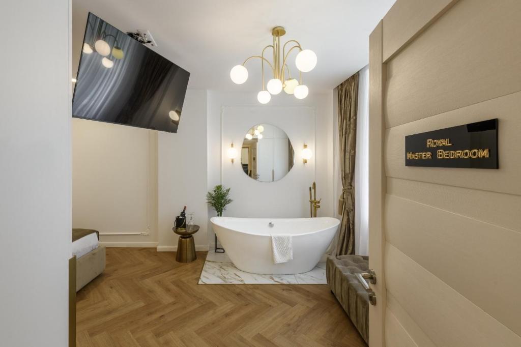 a bathroom with a large tub and a mirror at Eden Central Boutique Suites - Garden & Spacious Apartments in Cluj-Napoca