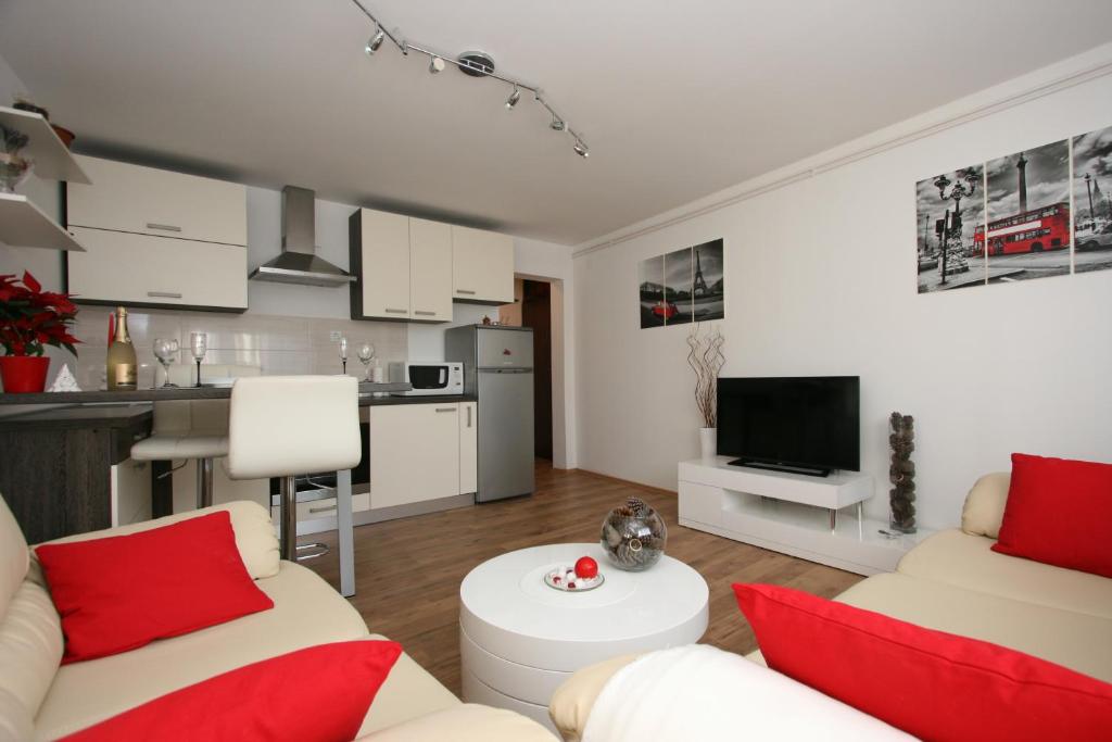 a living room with two couches and a kitchen at Apartments Zagreb Schone in Zagreb