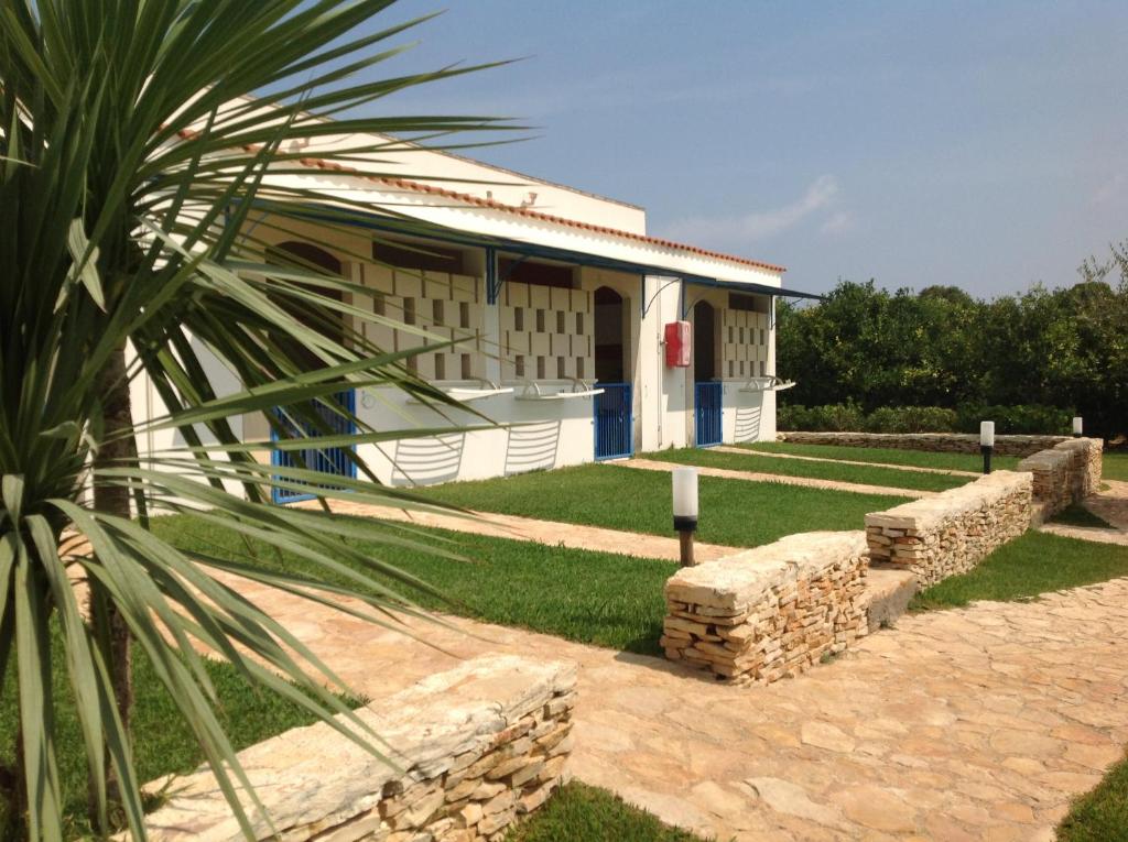 a building with a palm tree in front of it at Agriturismo L'Agrumeto in Otranto