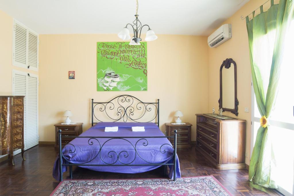 1 dormitorio con cama morada y espejo en Vacationers Refuge en Anzio