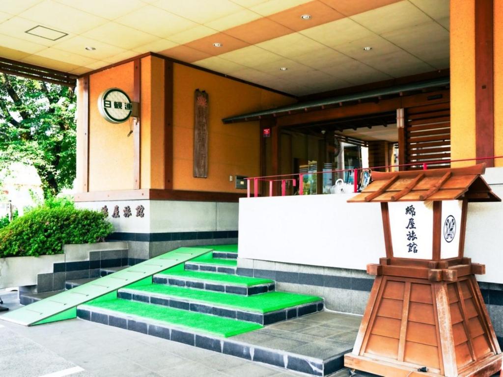 a building with green steps in front of a bar at 綿屋旅館 in Tsunan